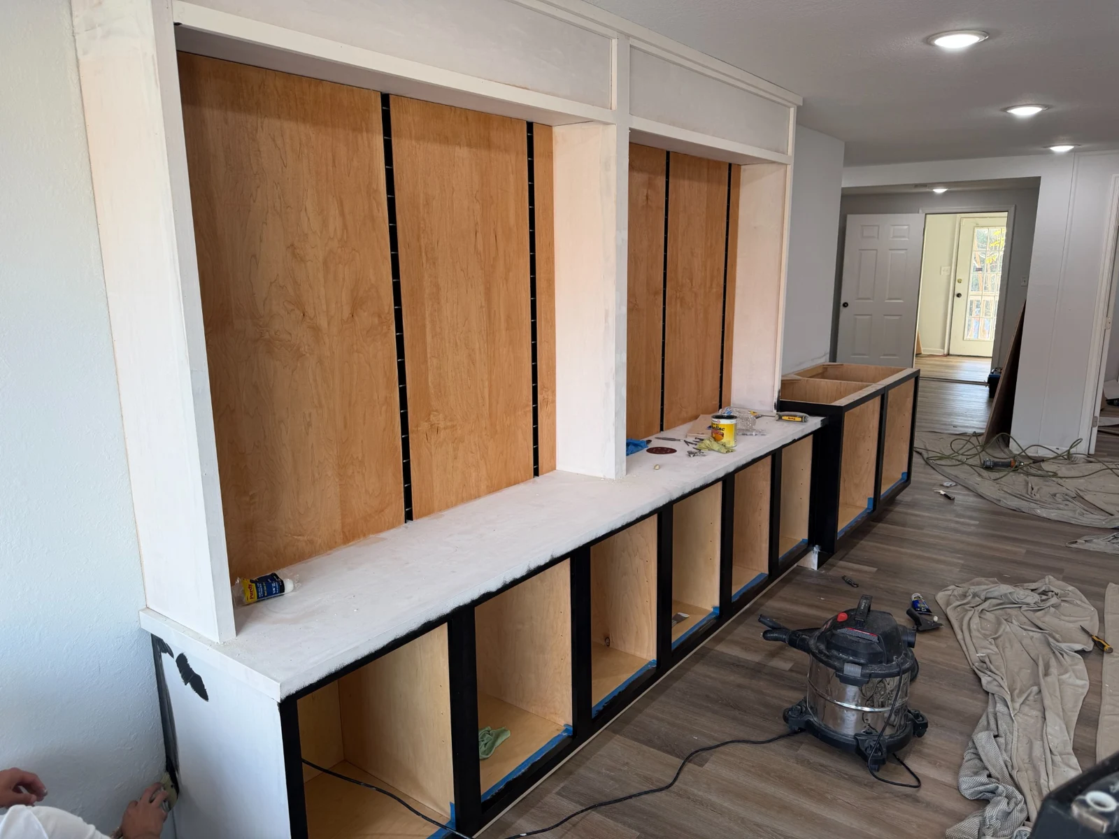 Side view of the VeloConcepts wall during construction with wood panels, primed counter and painted base frames